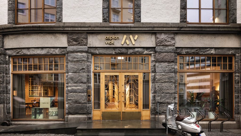 Inngangsparti med store vinduer og Asplan Viak-logo over dobbel tredør med vinduer.